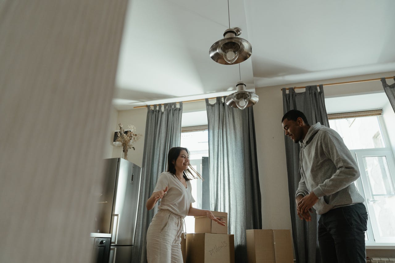 A joyful couple unpacks boxes in their new home, celebrating a fresh start.